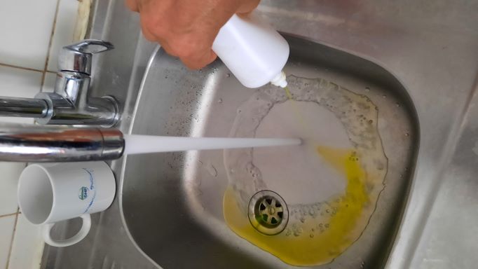 Contrôle GHP d'assainissement par colorant : versement du colorant dans l'évier